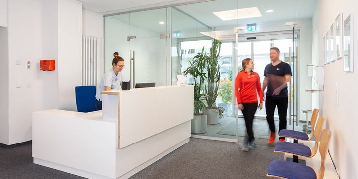 Blick von Innen auf Eingangsbereich und Rezeption der BG-Abteilung des VAMED Rehazentrum Karlsruhe