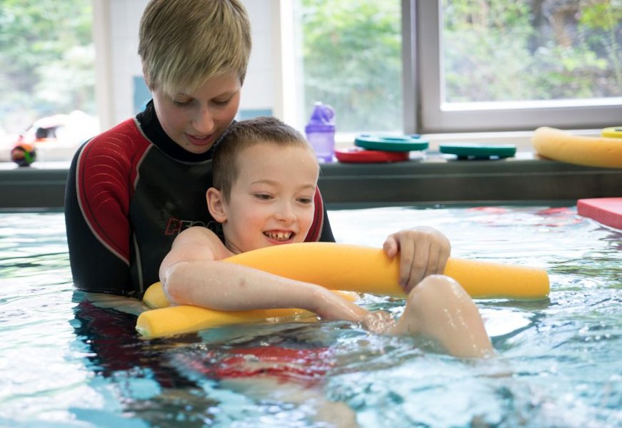 Junge im Therapiebad mit Therapeutin