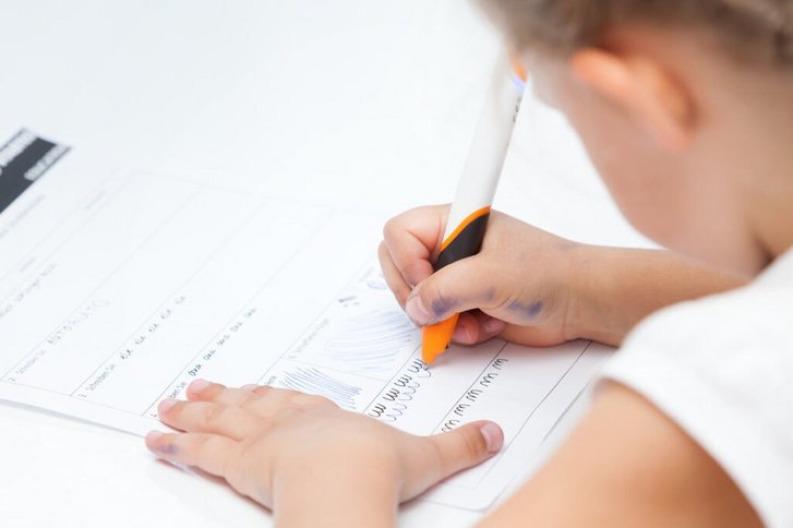 Nahaufnahme eines Maedchens, das Schreibuebungen in der Ergotherapie in Karlsruhe macht.