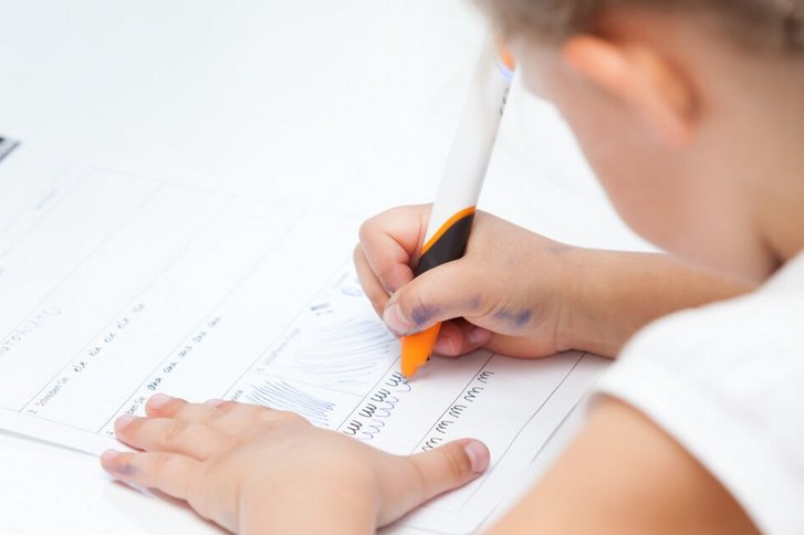 Nahaufnahme eines Maedchens, das Schreibuebungen in der Ergotherapie in Karlsruhe macht.