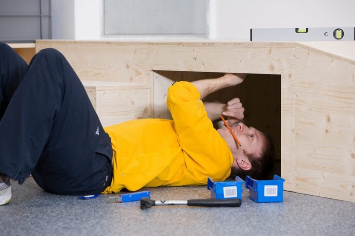 Patient uebt in Rueckenlage ueber Kopf zu arbeiten in der medizinisch beruflich orientierten Reha des VAMED Rehazentrums Karlsruhe