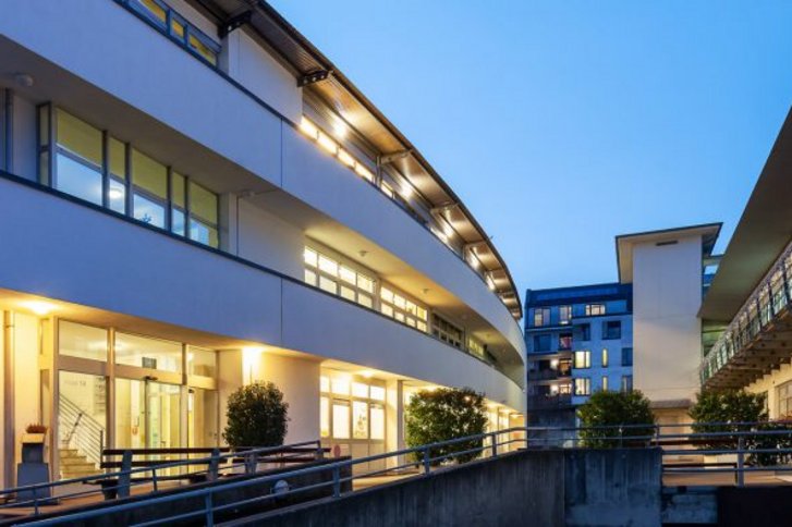 Blick auf das beleuchtete VAMED Rehazentrum in Karlsruhe bei Nacht