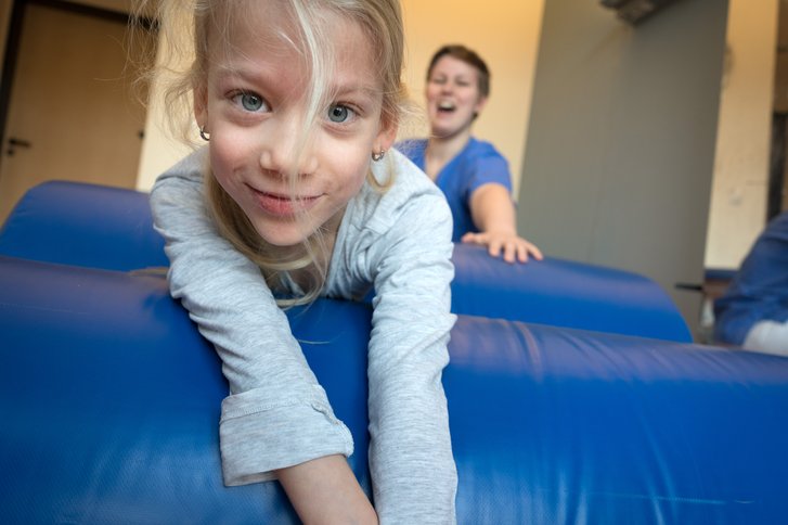 Maedchen und Physiotherapeutin lachen