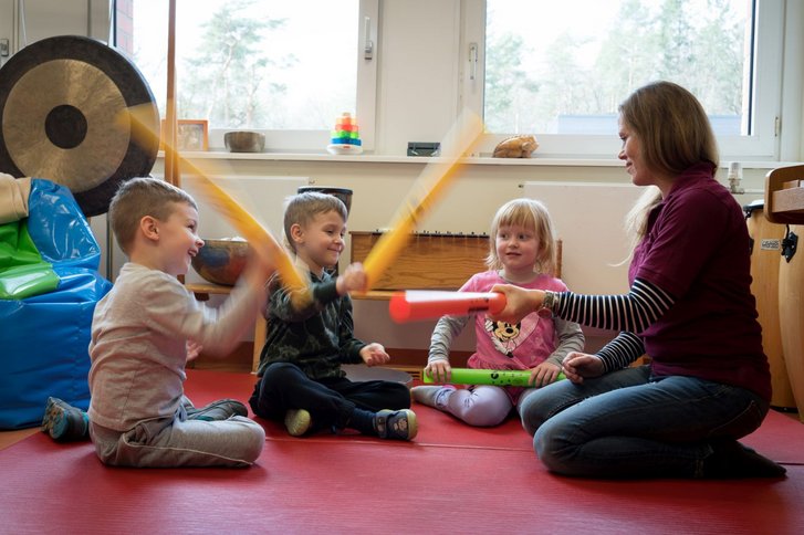 Kinder und Therapeutin spielen mit Troeten