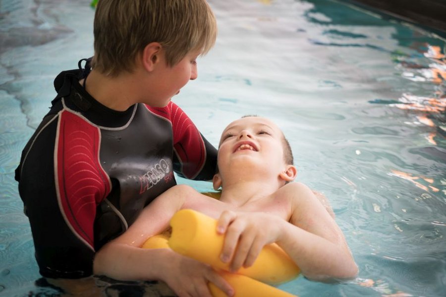 Junge im Bewegungsbad mit Therapeutin