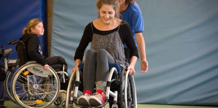 Jugendliche übt mit dem Rollstuhl